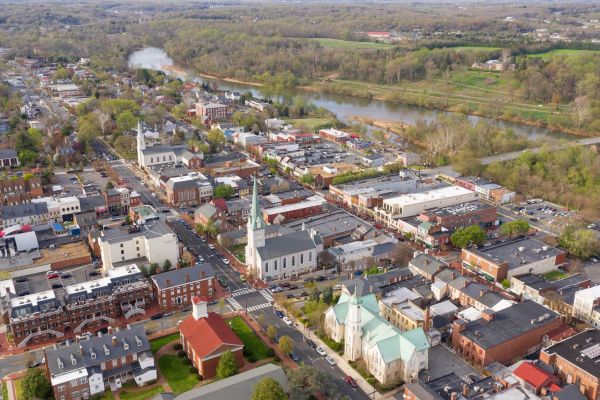 Attain at Towne Centre apartment homes with Aerial view of a small town with churches, buildings, river, and surrounding greenery.