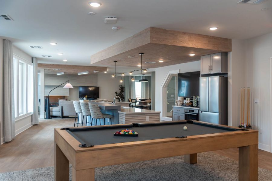 Attain at Towne Centre apartment homes with Modern open-concept game room and kitchen with a pool table, bar seating, and lounge area.