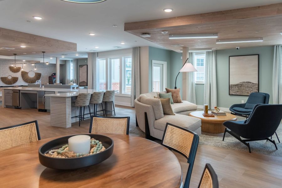 Attain at Towne Centre apartment homes with Modern open-concept living space with kitchen, dining table, sofa, and armchairs in neutral tones.