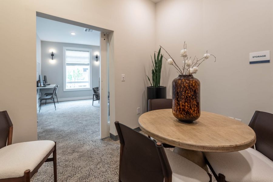 Attain at Towne Centre apartment homes with Small round table with four chairs, a brown vase, and a plant in a modern, neutral-toned office space.